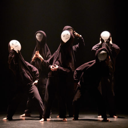 six dancers on stage with masks on